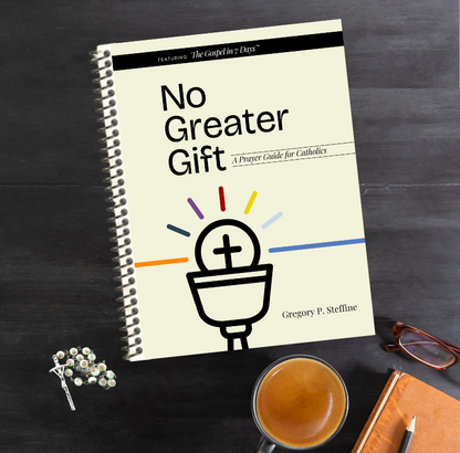 Book titled 'No Greater Gift' on a dark surface with a cup of coffee and glasses.